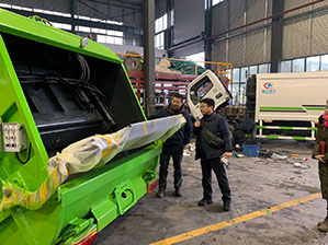 Un cliente de Corea del Sur llega a la fábrica y estudia el equipo de residuos de compactador.