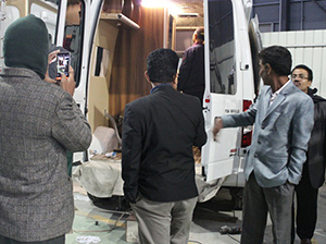 un cliente de bangladesh llega a la fábrica y estudia un camión de plataforma y un automóvil de turismo